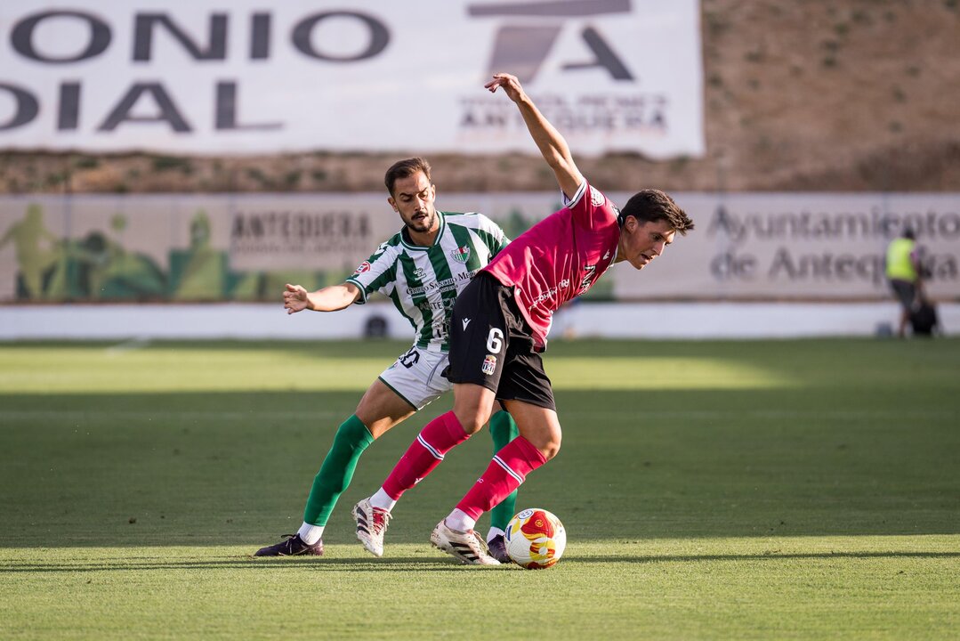 Fidalgo controla un balón ante un jugador local/Foto: ANTEQUERA CF